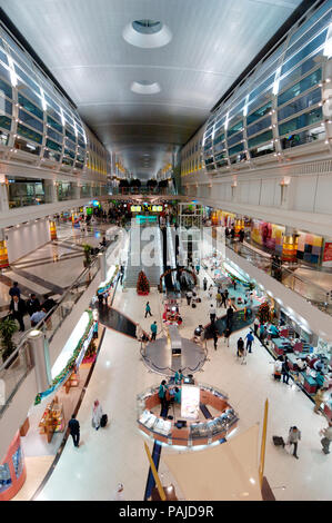 Passeggeri in negozi duty-free nell'area partenze con un albero di Natale e decorazioni di Dubai International Airport Hotel in Sheikh Foto Stock