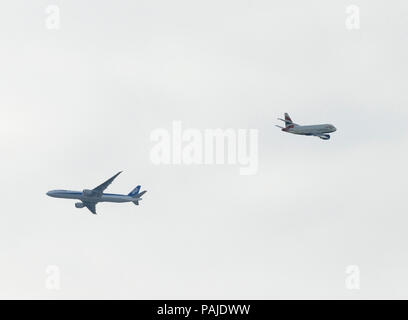 British Airways Airbus A318-100 salendo lungo il tragitto e un ANA Boeing 777-200 battenti lungo il tragitto Foto Stock