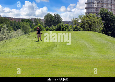 L'uomo falciare l'erba sulla collina Foto Stock