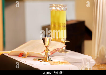 Calici d'oro sull'altare durante la massa Foto Stock