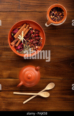 Mescolare il tè con la frutta secca e fiori secchi sulla tazza e teiera Foto Stock