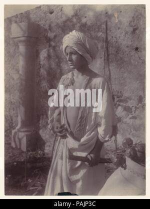 [Giovane in tunica bianca e la testa dentata Holding Scabbard, Sicilia, Italia]. Artista: Wilhelm von Gloeden (italiano, nato in Germania, 1886-1931). Dimensioni: 22,3 x 16,5 cm. (8 3/4 x 6 1/2 in.). Data: 1890s-1900s. Museo: Metropolitan Museum of Art di New York, Stati Uniti d'America. Foto Stock