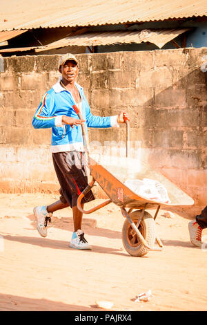 BANJUL (GAMBIA - Mar 14, 2013: gambiana non identificato piccolo uomo porta il carrello in Gambia, Mar 14, 2013. I principali gruppi etnici in Gambia è la mandi Foto Stock