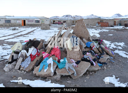 Lavavano i panni di una famiglia essiccazione su un mucchio di detriti di cemento nel piccolo villaggio di Huayllajara (sull'Altiplano, vicino a Laguna Colorada), Bolivia Foto Stock