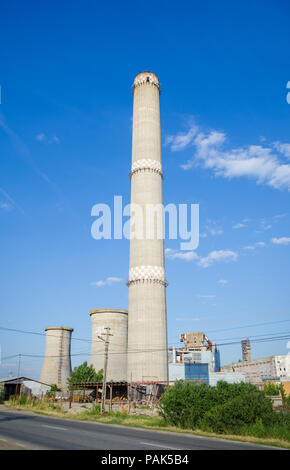 Vecchia fabbrica abbandonata forno in calcestruzzo con un alto statura sottile su un luminoso giorno suggerendo socialista comunista reliquie industriale Foto Stock