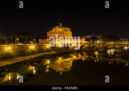 Roma, Italia - 29 Novembre 2015: Castel Sant Angelo in una calda notte con luci luminose tutto intorno e l'acqua riflettente del fiume Tevere passando t Foto Stock
