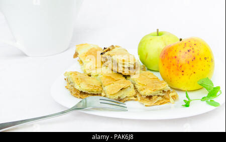 La torta di mele le fette su un piatto con uno sfondo bianco Foto Stock