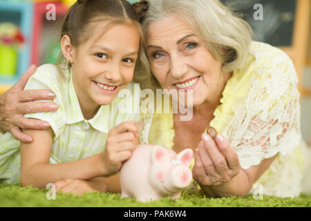 Vecchia donna con salvadanaio Foto Stock