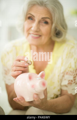 Vecchia donna con salvadanaio Foto Stock