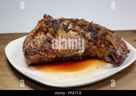 Grigliata di tri punta a fette di bistecca su una piastra bianca sul tavolo della cucina Foto Stock