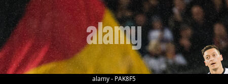 Hannover, Germania. Undicesimo oct, 2016. Calcio: World Cup qualifier, Germania vs Irlanda del Nord, nell'HDI Arena: Mesut Ozil in piedi in campo mentre una grande bandiera tedesca onde nelle tribune. Credito: Julian Stratenschulte/dpa/Alamy Live News Foto Stock