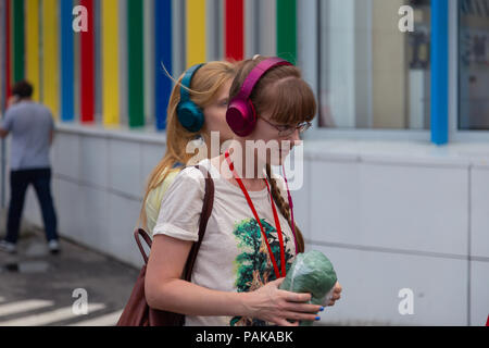 Mosca, Russia. Il 22 luglio 2018. Un gruppo di giovani in identiche multi-colore di cuffie Sony 'h.ear on" si sono riuniti per la parte vicino all'ingresso della stazione metro Savelovskaya. Dopo un paio di minuti il pubblico ha iniziato ad applaudire e con sorrisi sui loro volti rapidamente disciolto in mezzo alla folla di passeggeri. Remote Mosca è una performance-viaggio attraverso Mosca per un gruppo di 50 persone. Questo è un progetto teatrale di un nuovo formato in genere di 'promenade-Performance', combina gli elementi di una performance, una escursione, un gioco per computer e una ricerca. Credito: Andrey Yanevich/Alamy Live News Foto Stock