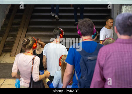 Mosca, Russia. Il 22 luglio 2018. Un gruppo di giovani in identiche multi-colore di cuffie Sony 'h.ear on" si sono riuniti per la parte vicino all'ingresso della stazione metro Savelovskaya. Dopo un paio di minuti il pubblico ha iniziato ad applaudire e con sorrisi sui loro volti rapidamente disciolto in mezzo alla folla di passeggeri. Remote Mosca è una performance-viaggio attraverso Mosca per un gruppo di 50 persone. Questo è un progetto teatrale di un nuovo formato in genere di 'promenade-Performance', combina gli elementi di una performance, una escursione, un gioco per computer e una ricerca. Credito: Andrey Yanevich/Alamy Live News Foto Stock