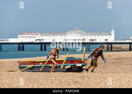 Brighton, Regno Unito. Il 24 luglio 2018. Tirando una barca a terra sulla spiaggia di Brighton Credito: Andrew Hasson/Alamy Live News Foto Stock