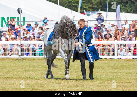 Brockenhurst, Hampshire, Regno Unito. 24 luglio 2018. La folla affluisce al primo giorno del New Forest & Hampshire County Show in una calda giornata di sole. Ben Atkinson e il team Atkinson Stunt display, apparsi in Poldark e Peaky Blinders, entusiasmano la folla con i loro trucchi e acrobazie, tra cui Roman Riding, Drags, Falls, Pick UPS, ribaltamenti, cavalli che allevano e si stendono. Crediti: Carolyn Jenkins/Alamy Live News Foto Stock