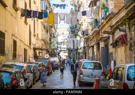 Napoli, Italia - circa ottobre, 2017: Vista di residenti a piedi verso il basso un tipico congestionato servizio lavanderia-rigato street del centro storico. Foto Stock