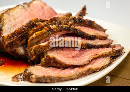 Grigliata di tri punta a fette di bistecca su una piastra bianca sul tavolo della cucina Foto Stock