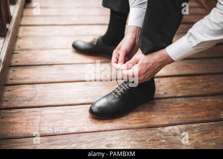 Uomo che indossa in pelle marrone scarpe classic, pantaloni neri e camicia bianca, stile business Foto Stock