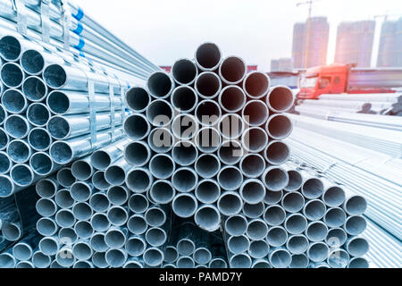Tubi in acciaio Costruzione industria accatastati nel magazzino di fabbrica Foto Stock