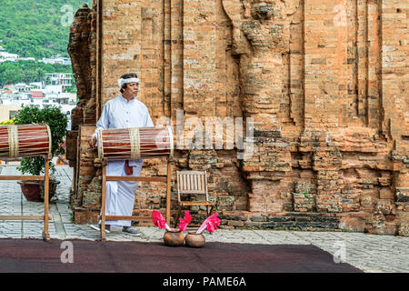 Nha Trang, Vietnam - Dic 23, 2017: uomo in abito tradizionale è la riproduzione in locale i fusti realizzati nella parte anteriore del Po Nagar tempio Cham towers di Nha Trang, K Foto Stock