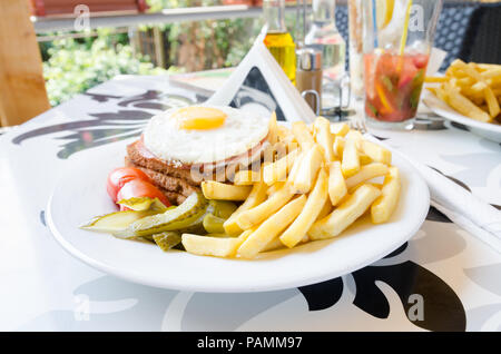 Croque madame panino con patate fritte su una tavola di fantasia Foto Stock