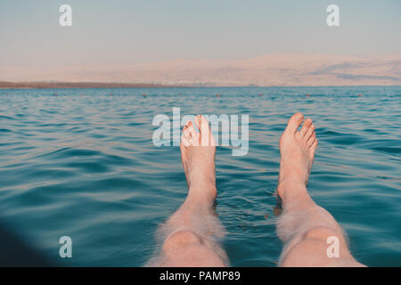 Piedi di bob e galleggiare nel Mar Morto, Israele, che è così salato è impossibile per un corpo umano per lavello Foto Stock