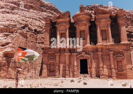 La bandiera giordana Vola di fronte al Monastero, una delle strutture più grandi in città perduta di Petra Foto Stock