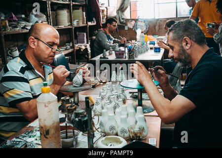 Due palestinesi vasai danno una mano di vernice decorativa per alcuni argilla bianca porcellana Foto Stock