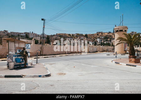 Un Forze di Difesa Israeliane soldato sta di guardia in un rifugio accanto ad una torre di avvistamento in un insediamento ebraico a Hebron, Cisgiordania Foto Stock