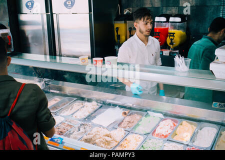 Un giovane uomo lavora dietro il gelato mobile in corrispondenza di un ristorante a Ramallah, Palestina, famoso per la sua appiccicosa, cremosa crema di ghiaccio Foto Stock