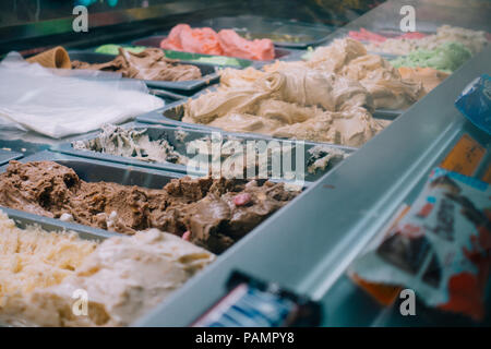 Vari gusti di gelato in vendita all'interno della vetrina di una popolare gelateria a Ramallah, capitale della Palestina Foto Stock