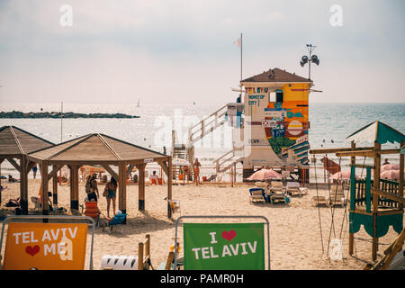 Beachgoers rilassarsi nelle sedie e sulla sabbia al colorato Frishman spiaggia di Tel Aviv, Israele Foto Stock