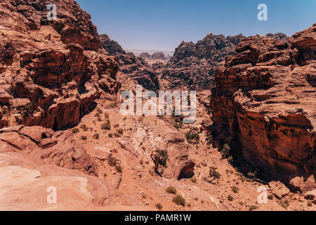 Guardando verso il basso in un canyon rocciosi vicino al monastero Ad-Deir in Petra, Giordania Foto Stock