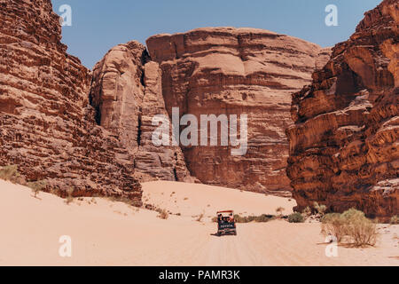 Una Toyota raccoglitore è sopraffatte come unità tra le enormi formazioni rocciose di Wadi Rum National Park, Giordania Foto Stock