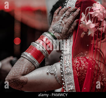 Candide foto del bellissimo Indian sposa in abito tradizionale indossando wedding schiave e Crimson Red dress in Indiana nozze indù Foto Stock