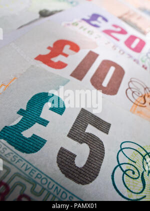 Close-up mostra banca britannica note in una linea. Messa a fuoco selettiva su cinque libbre. Foto Stock