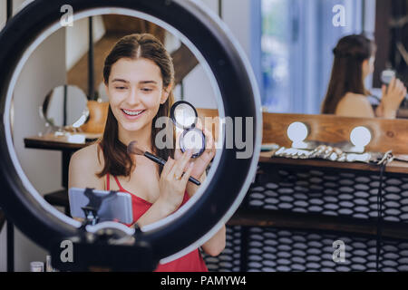 Sorridente piacevole make up artist rendendo master class Foto Stock