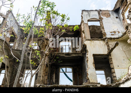 Le rovine e ricoperta di vegetazione la facciata interna di un vecchio edificio storico, danneggiate e distrutte durante la guerra civile a Beirut, Libano Foto Stock