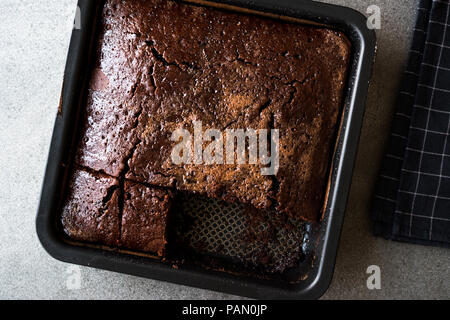 Square succosa spugna di cioccolato torta umida con la salsa in stampo. Concetto di dessert. Foto Stock