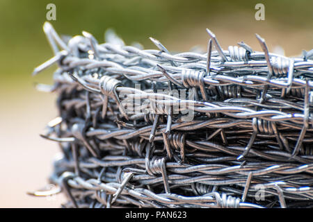 Close up su una pila/ rotolo di shiny nuovo filo spinato Foto Stock