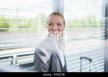 Ritratto di sorridente imprenditrice maturo in attesa in corrispondenza della piattaforma Foto Stock