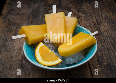 Fatta in Casa popsicles arancione nel recipiente Foto Stock
