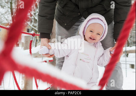 Ritratto di sorridente bambina con il padre su playgroud in inverno Foto Stock