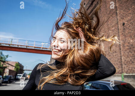 Ritratto di ridere donna con capelli di soffiatura Foto Stock