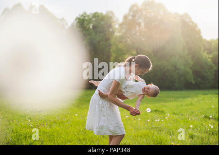 Madre e figlia giocando sul prato in estate Foto Stock