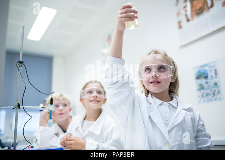Gli studenti nella classe di scienze sperimentando con liquido Foto Stock