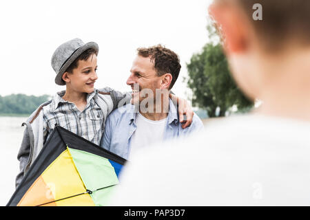 Padre Felice con due figli e kite all'aperto Foto Stock