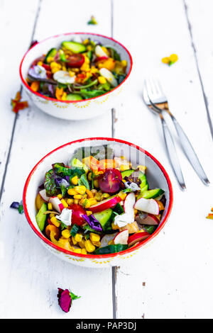 Ciotole di insalata mista con fiori commestibili Foto Stock