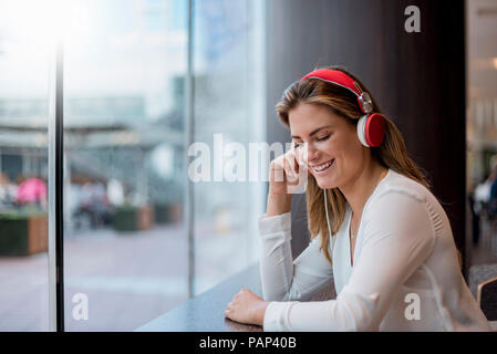 Felice giovane donna l'ascolto di musica con le cuffie Foto Stock