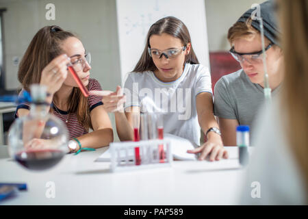 Gli studenti nella classe di scienze sperimentando con tubi di prova Foto Stock